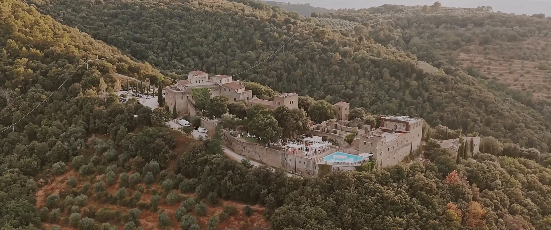 Castello di Rosciano among woods and olive groves, seen by drone, a frame from Cathrin and Philip’s wedding film