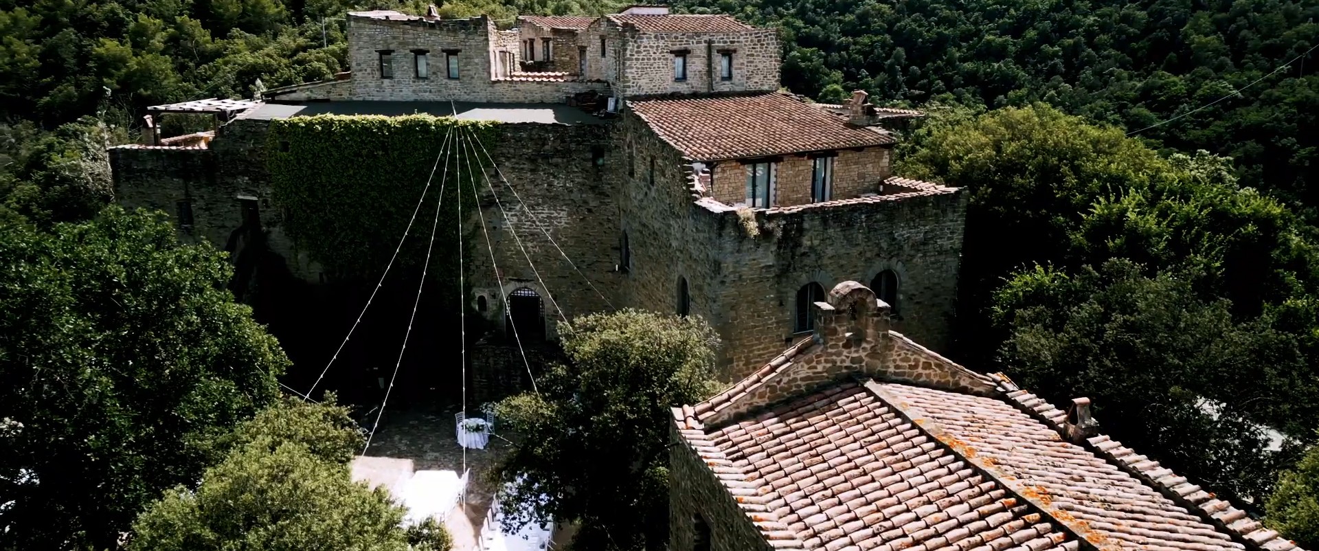 Le mura e i tetti del Castello di Rosciano dall’alto, con le luci appese sul cortile, fotogramma dal film di Gianni e Sophie