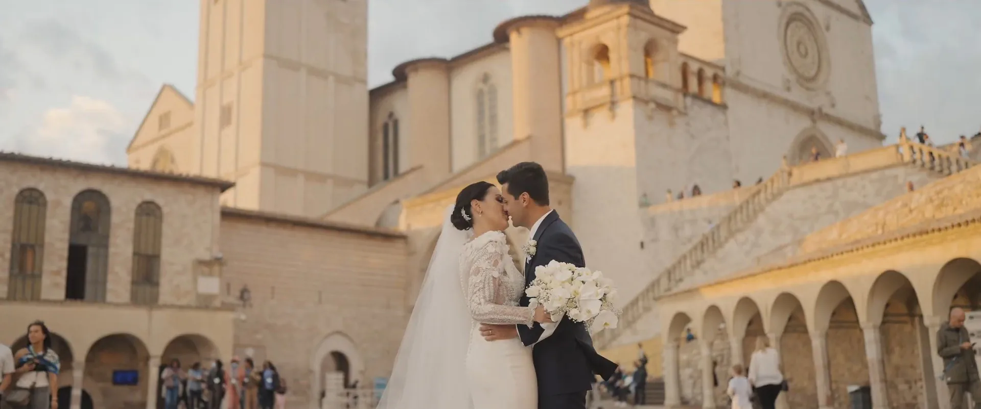 Iago and Benedetta kissing in the lower square of the Basilica of Saint Francis, Assisi, a frame from their wedding film
