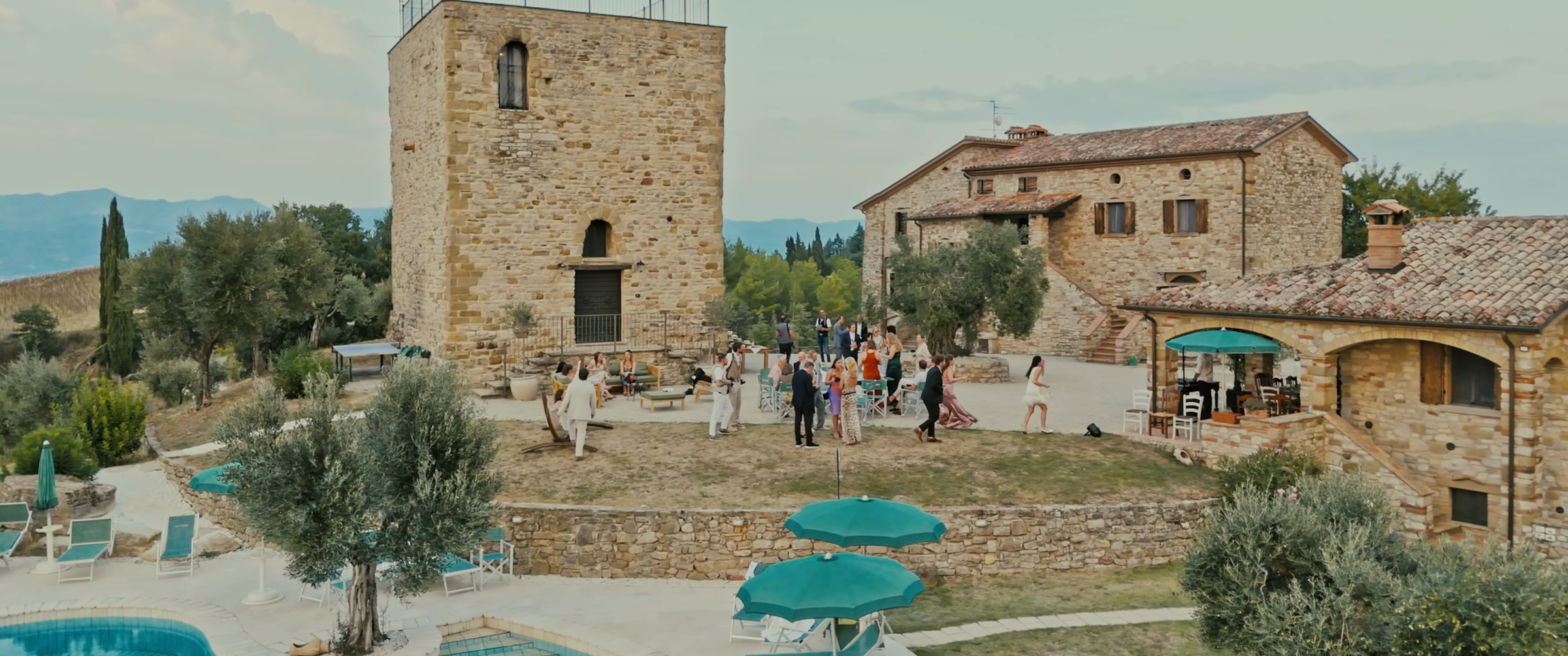 Gli ospiti davanti alla torre medievale e al casale della Torre di Celle, fotogramma dal film di Tyler e Jaime