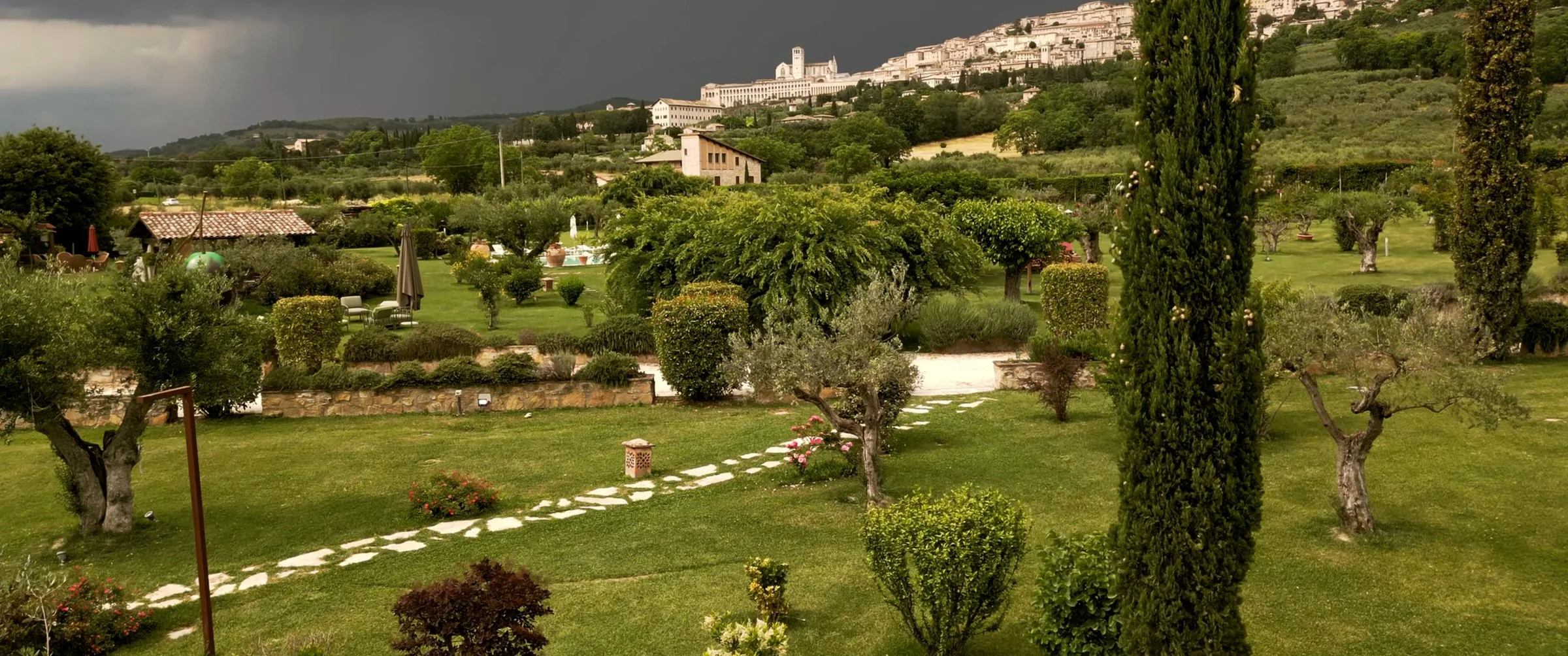 The garden of Tenuta di San Masseo with Assisi in the background