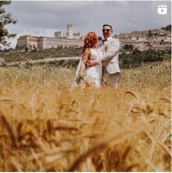Sposi abbracciati nel grano davanti ad Assisi — reel Instagram di Cinemarry