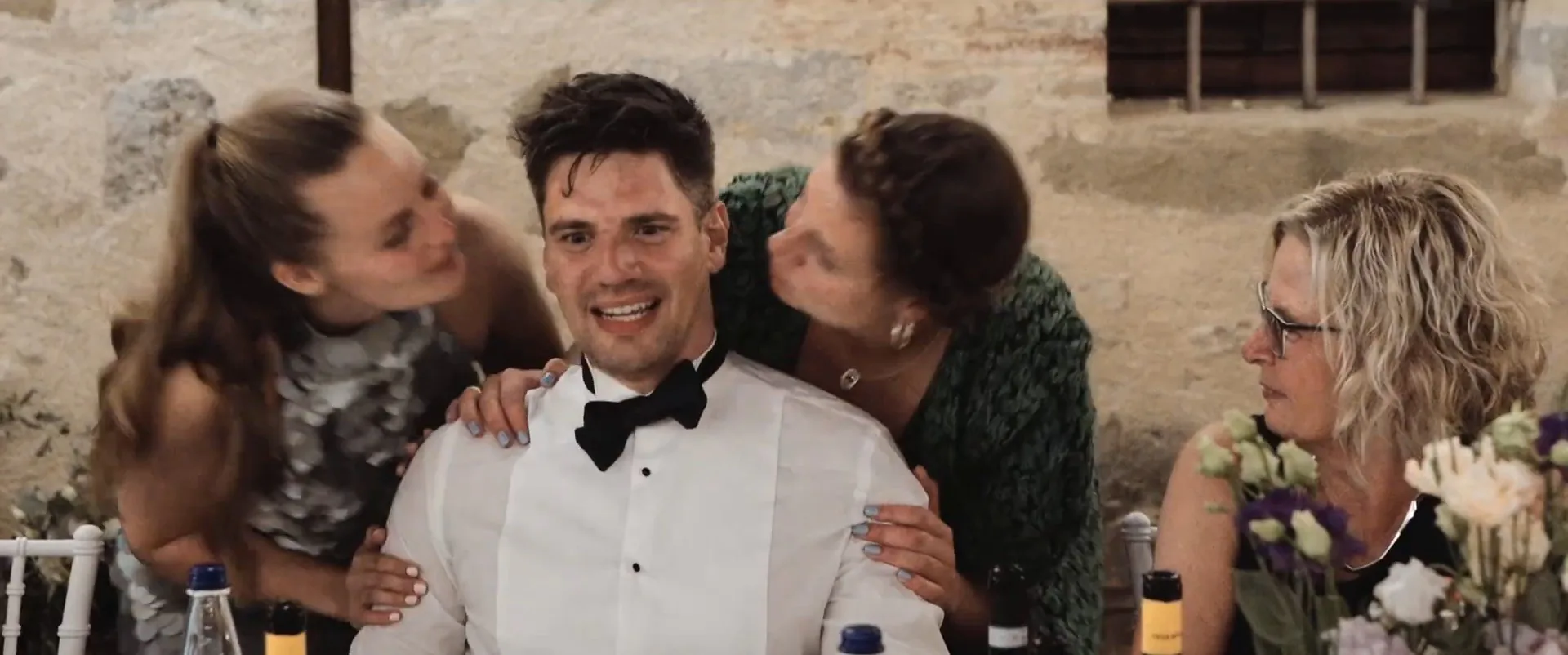 The bride’s friends celebrating the groom at the table during the reception, a frame from Rune and Cecilia’s film